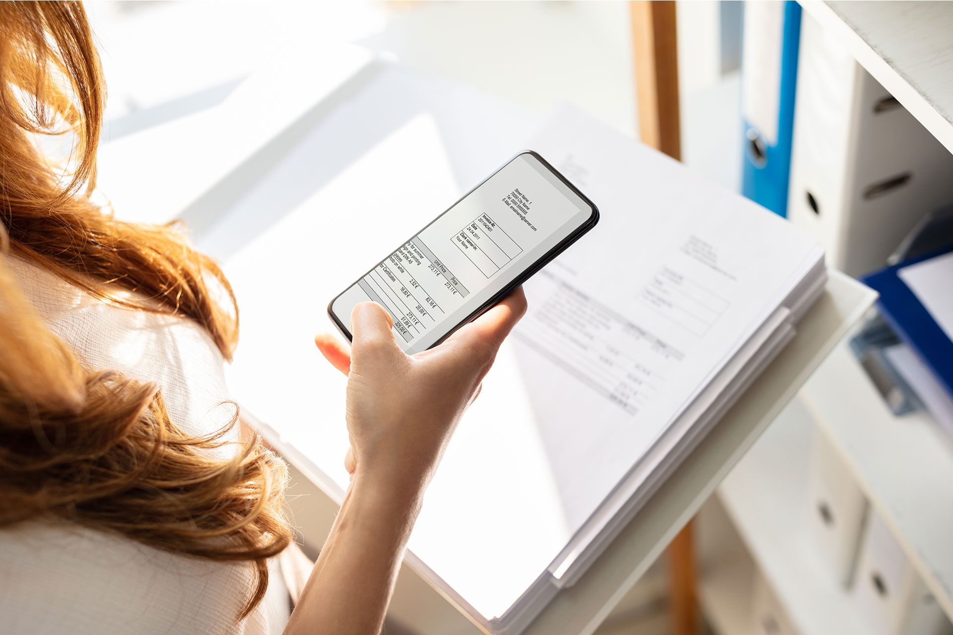 Photograph of a person scanning a document using the Dropbox mobile app.