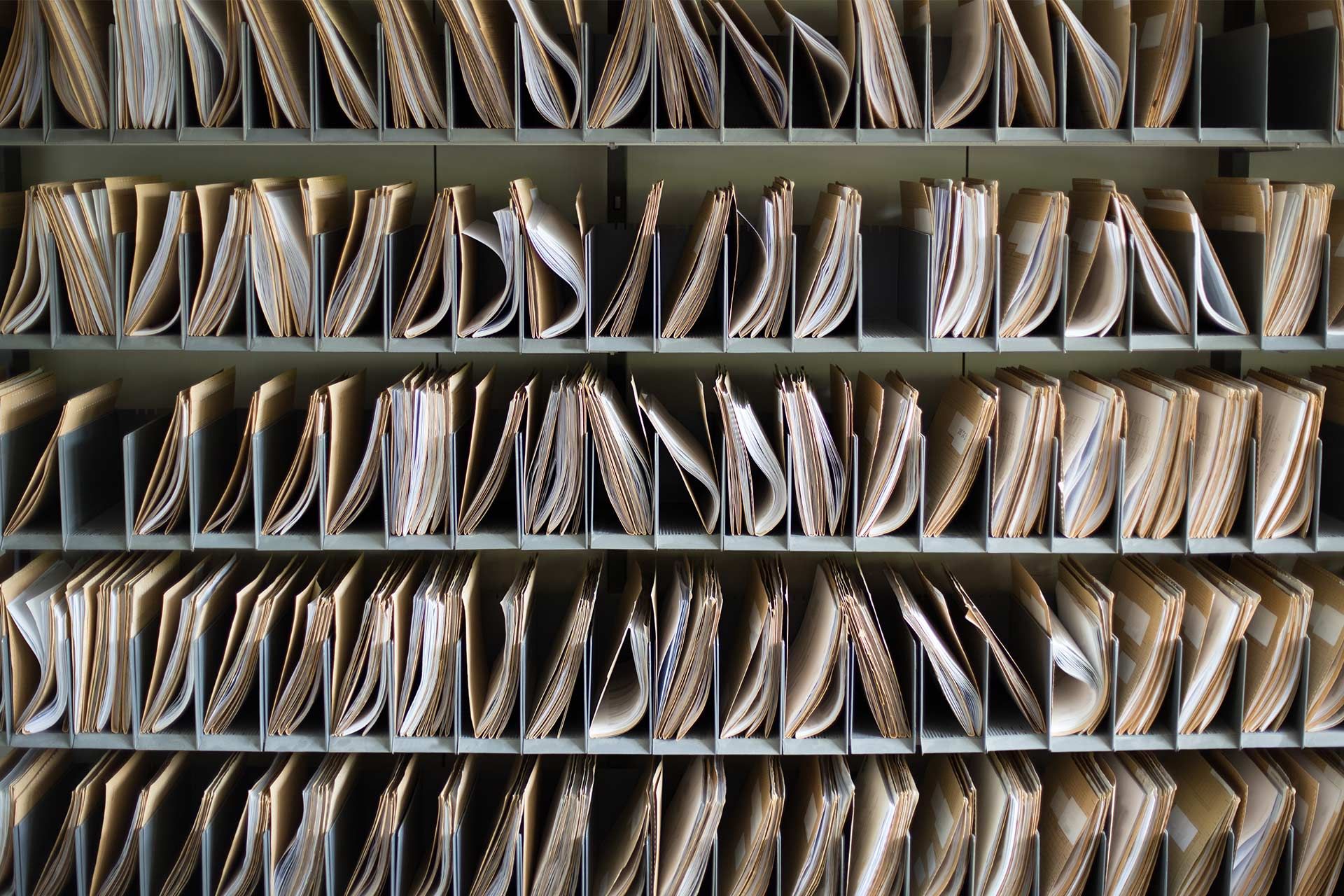 Rows of organised file folders on shelves, representing the concept of file organization, compression and storage.
