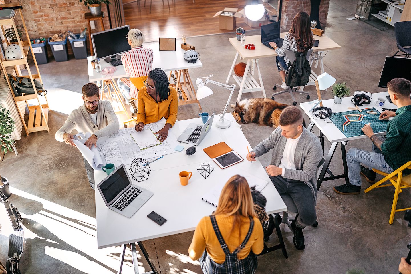People sitting around a table in an office looking at building plans.