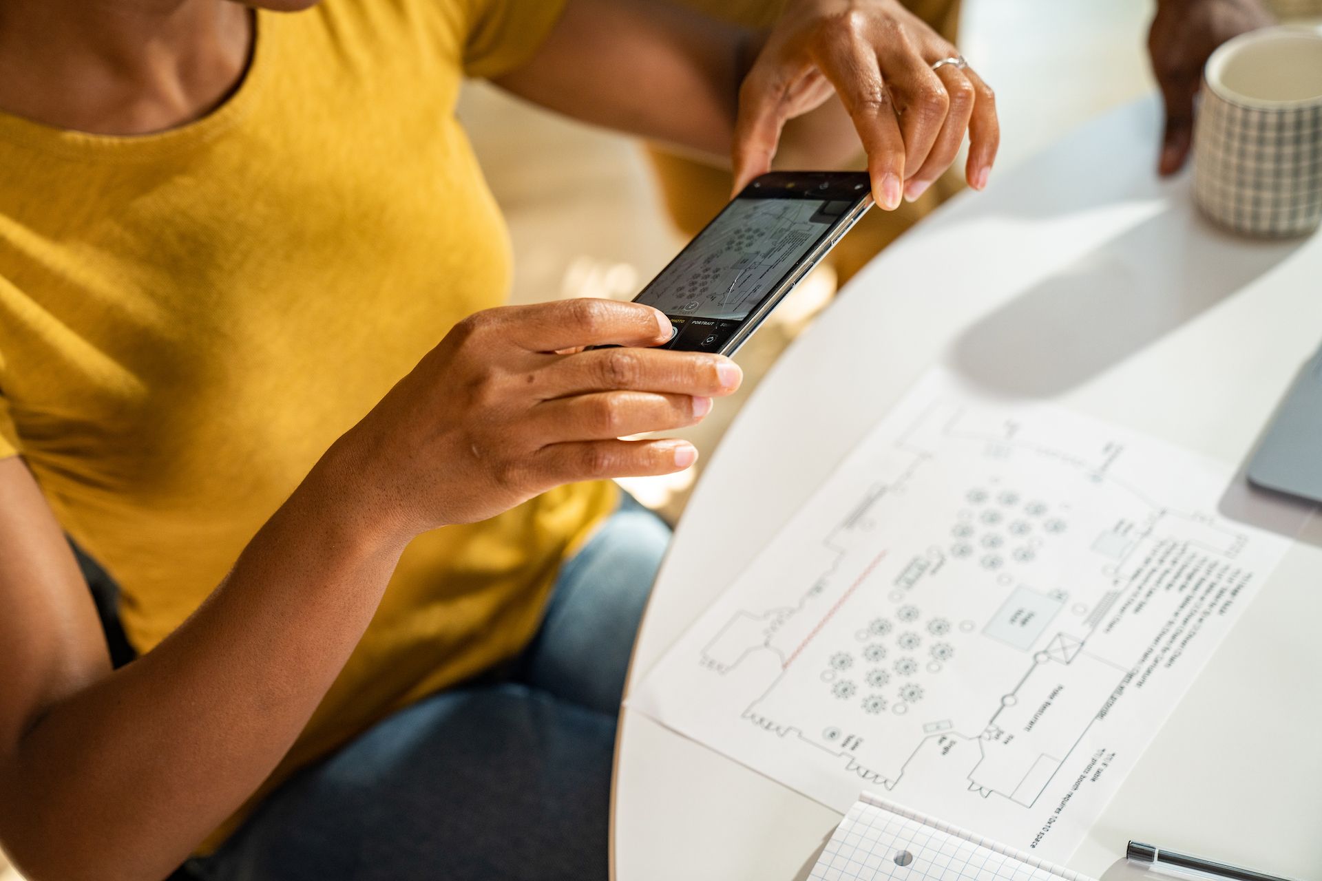 Una persona usa un iPhone per scattare una foto di alcuni piani, pronti per la sincronizzazione con il proprio account iCloud e altri dispositivi iOS.