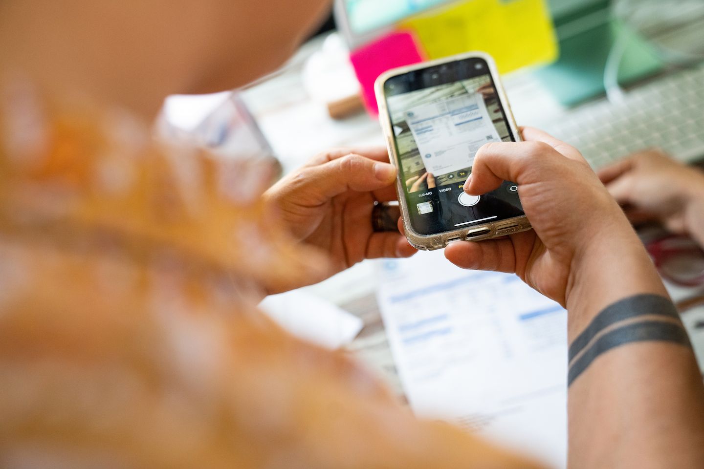 A solopreneur using their phone to convert physical files.