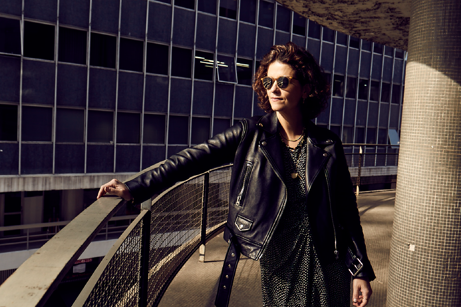 Ana Strumpf leaning against a metal railing outside a building