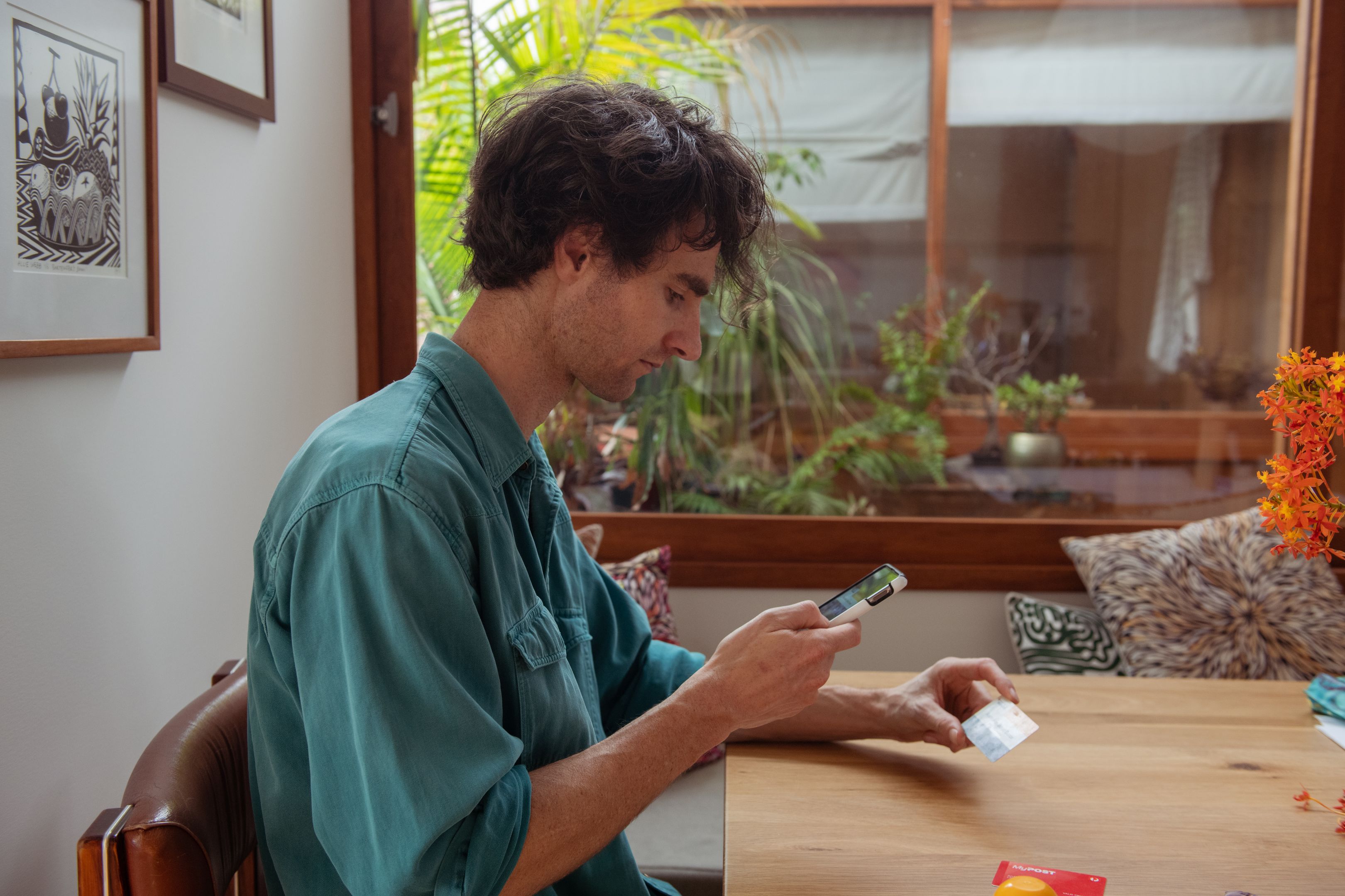 A person creates a copy of an identification card by taking a picture of it on their mobile device.