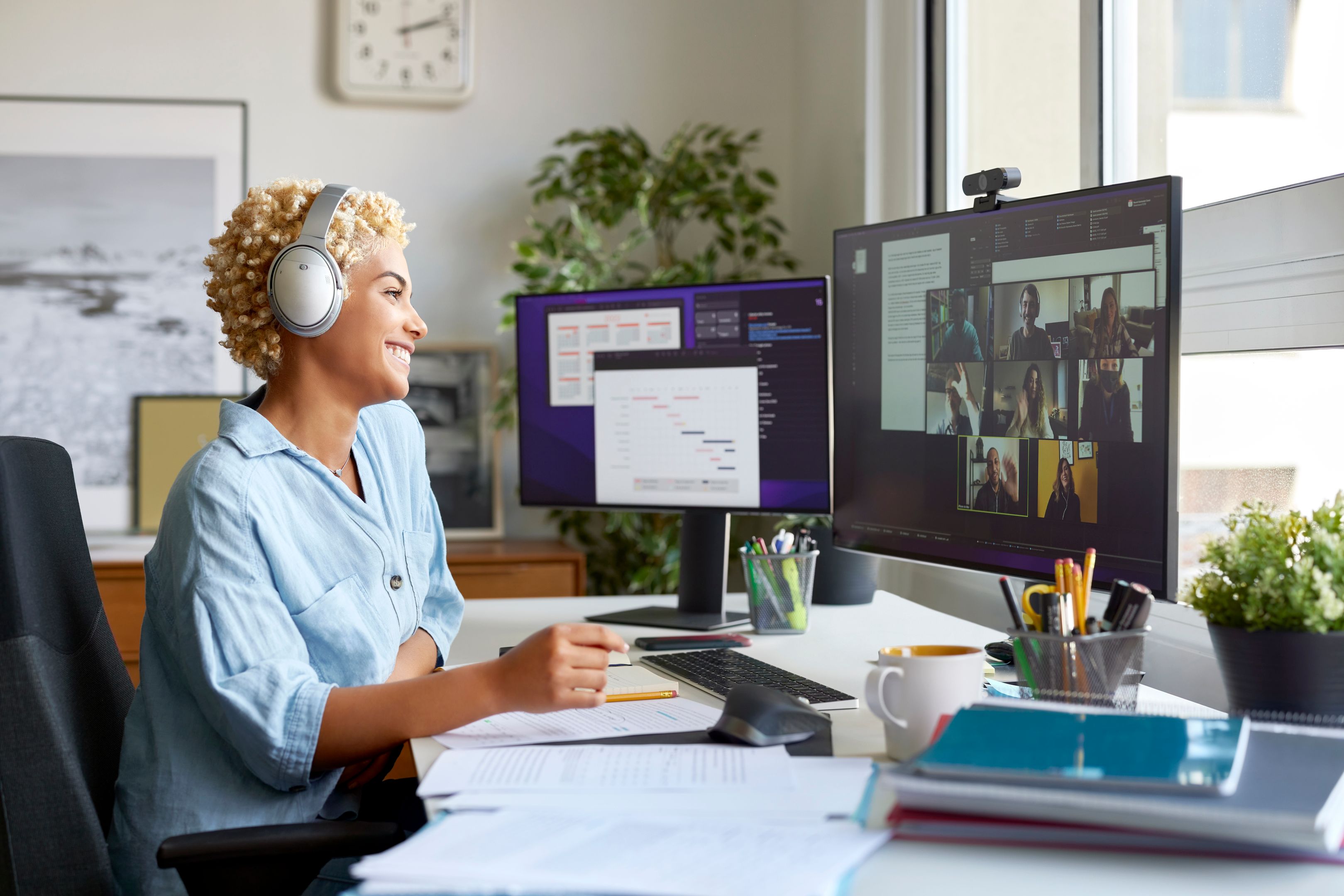 A person sits at their home desk while collaborating with colleagues on a call.