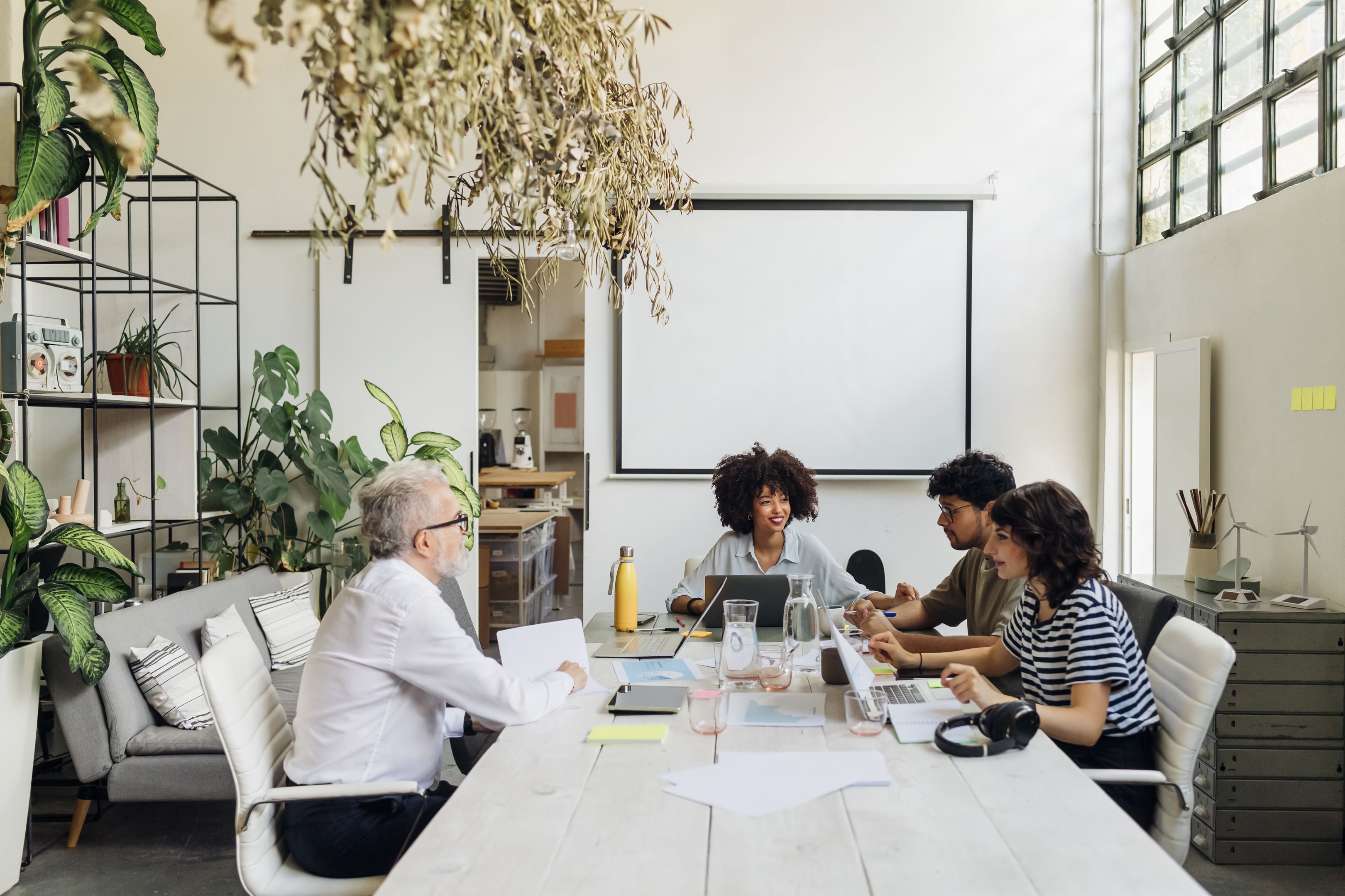 Three professionals in a meeting with a client.