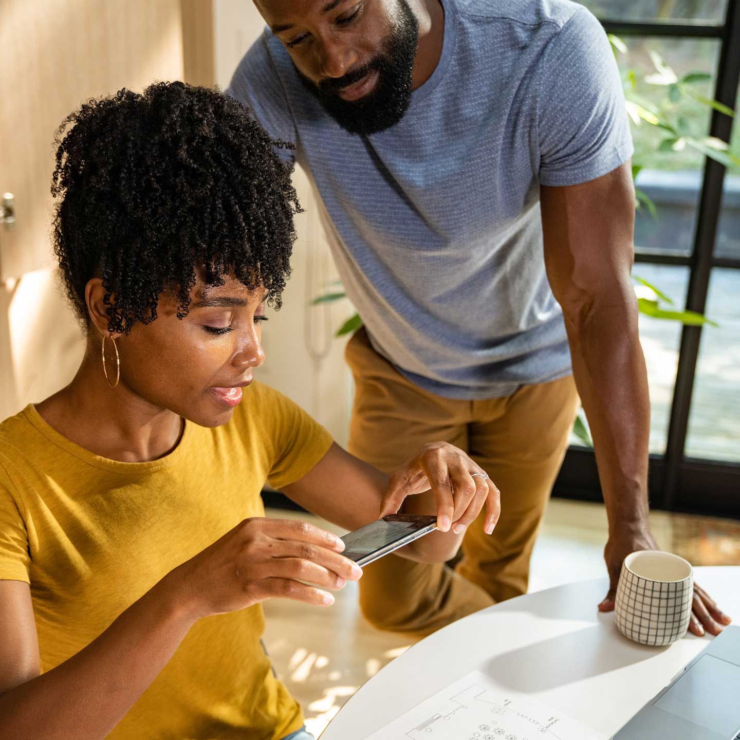 Photograph of a couple scanning a document using the Dropbox mobile app.