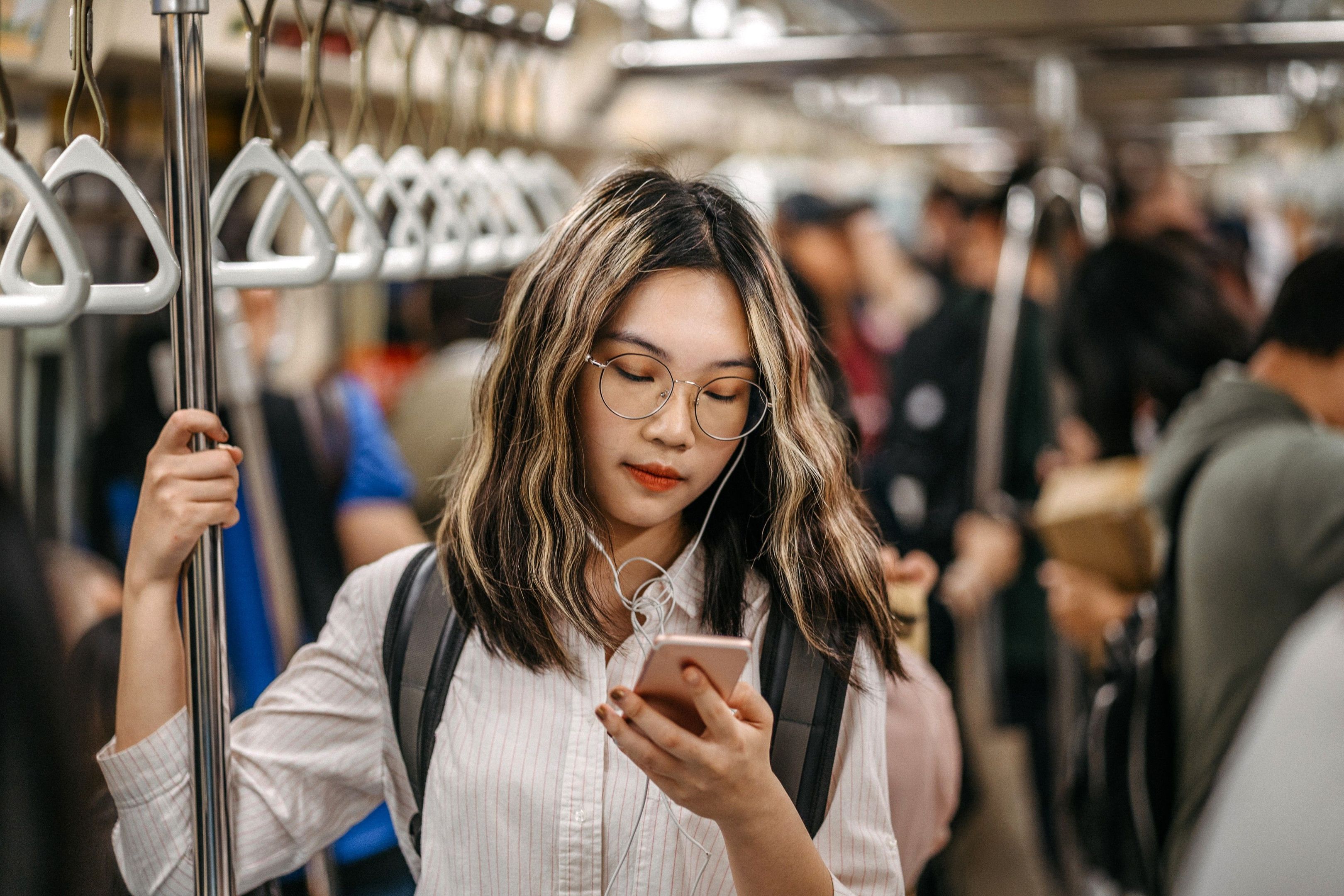 Person watch a video on their phone whilst riding a metro train
