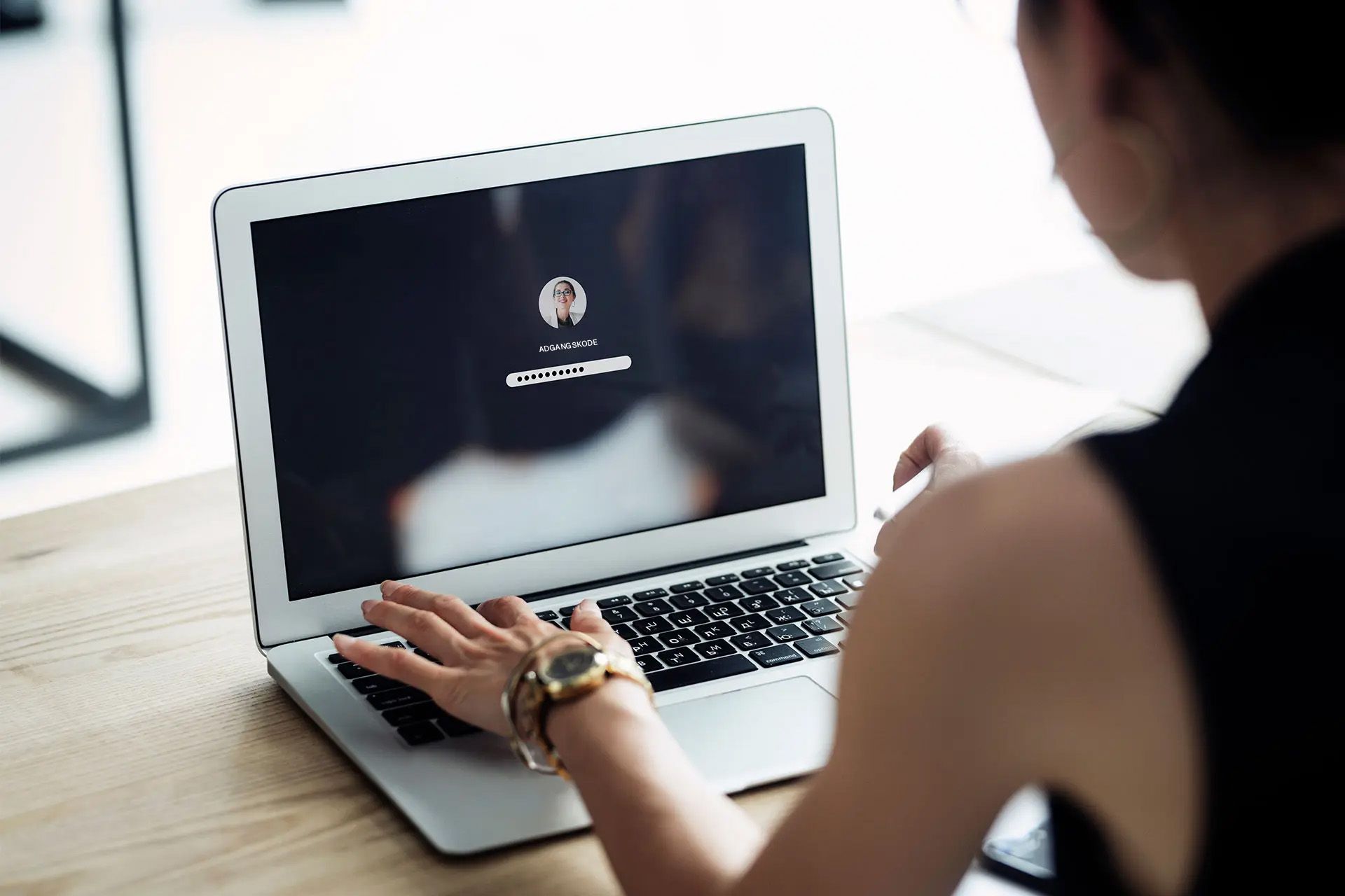Person, der indtaster en adgangskode på en login-skærm til en bærbar computer, der understreger sikker adgang til filer.