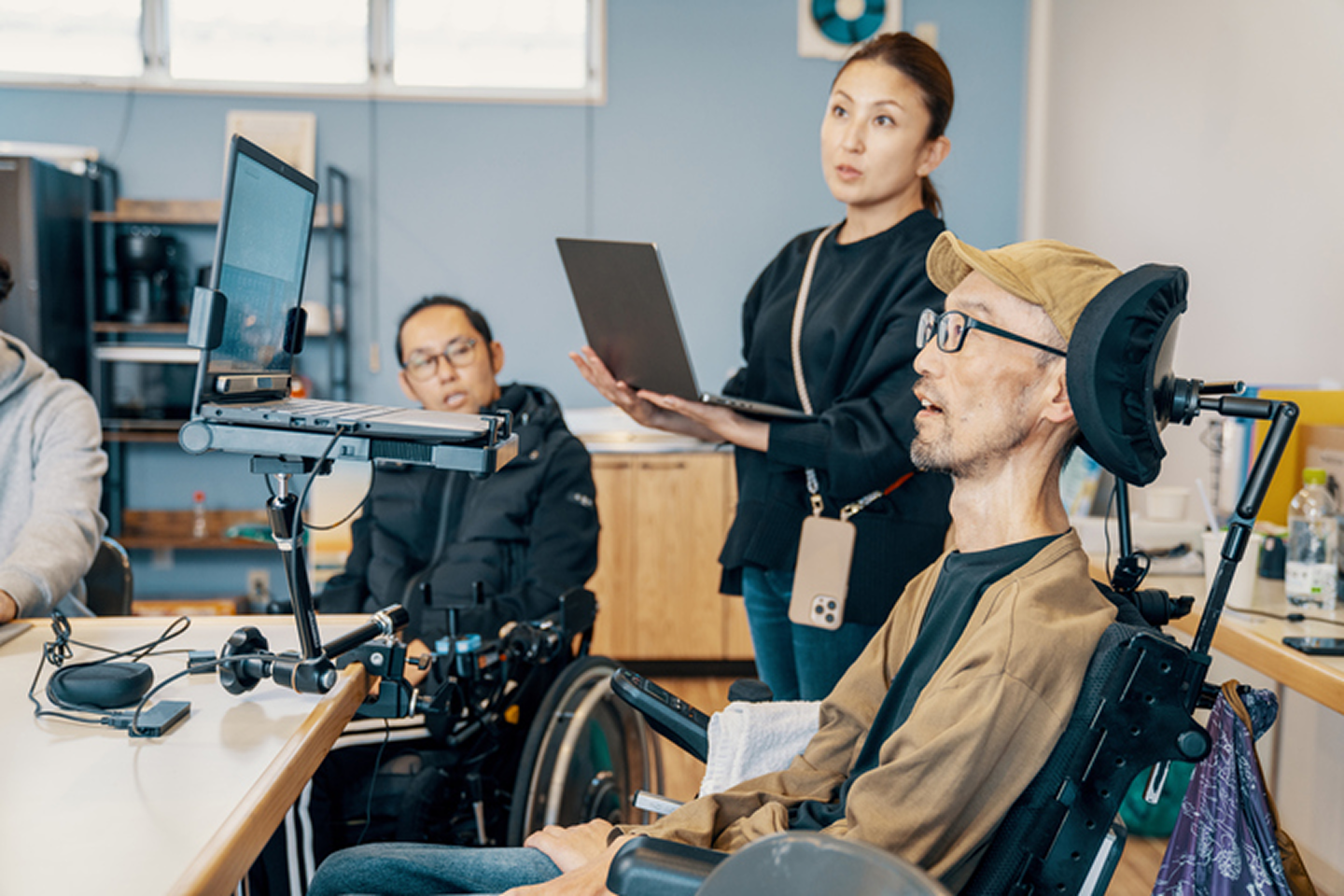 Trois personnes travaillent dans un bureau, deux collègues en fauteuil roulant.