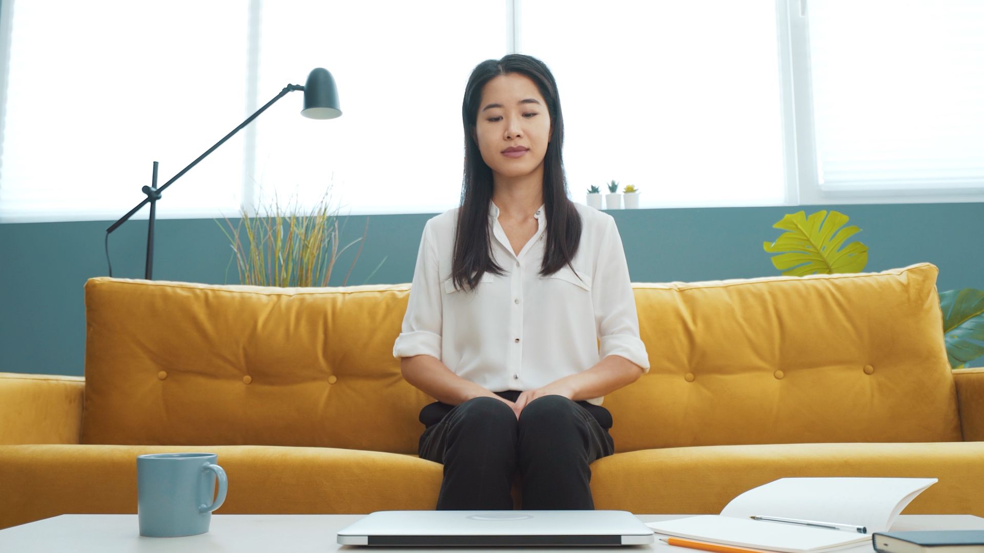 Vrouw die op een gele bank zit en op het punt staat om aan haar werk te beginnen