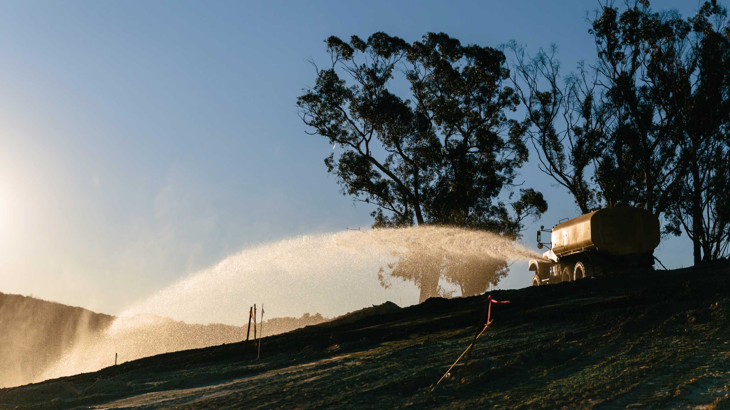 A truck spraying water on a field