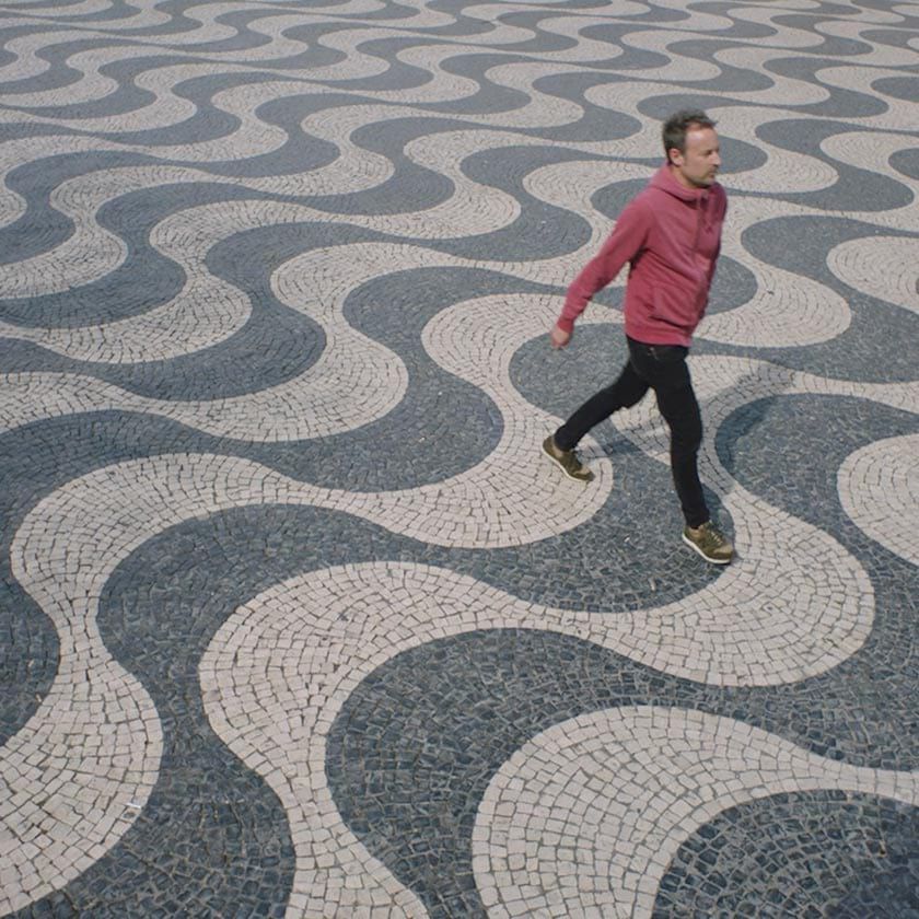 A person walking across a patterned tile floor