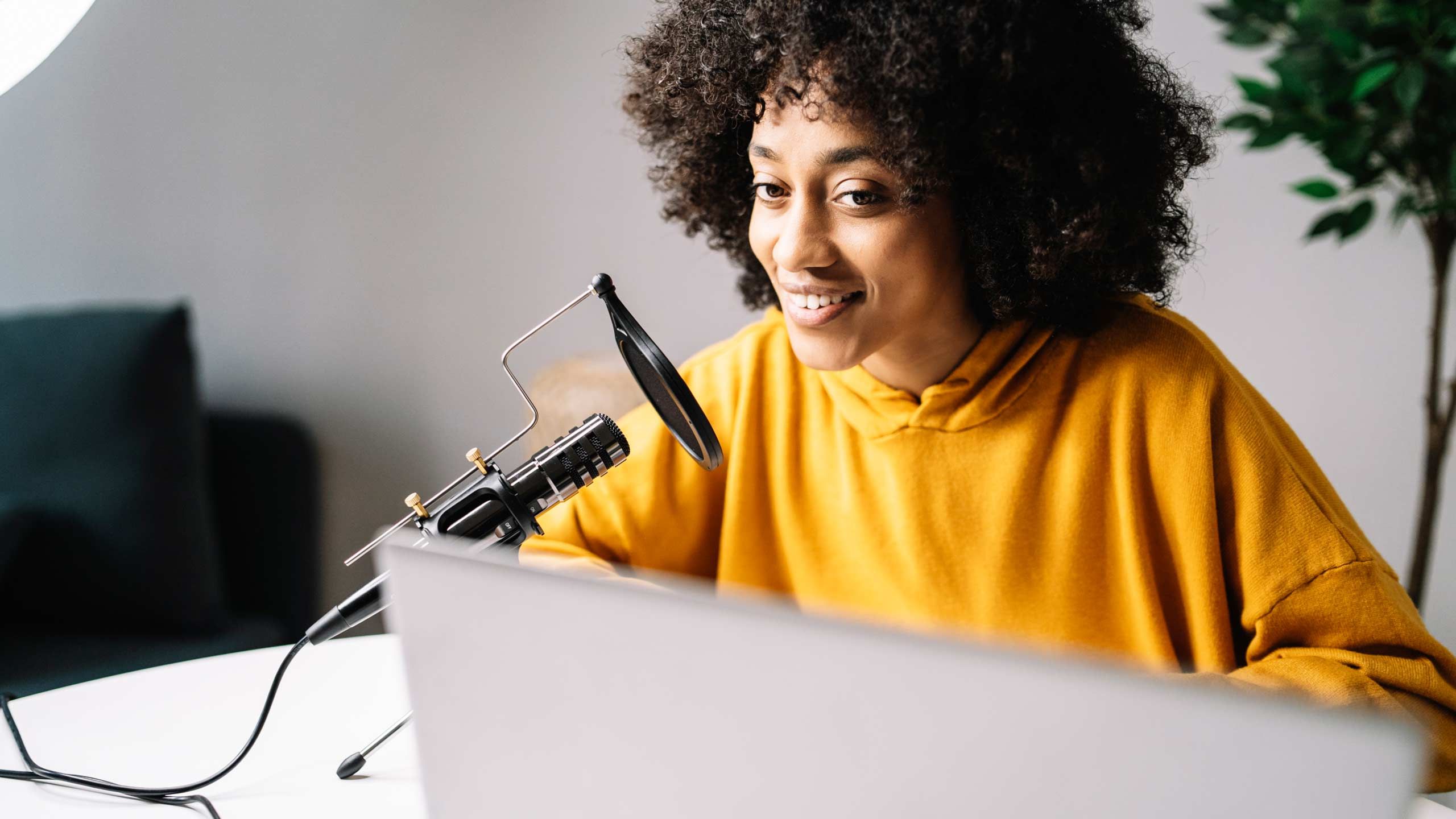 A woman speaking into a desktop microphone