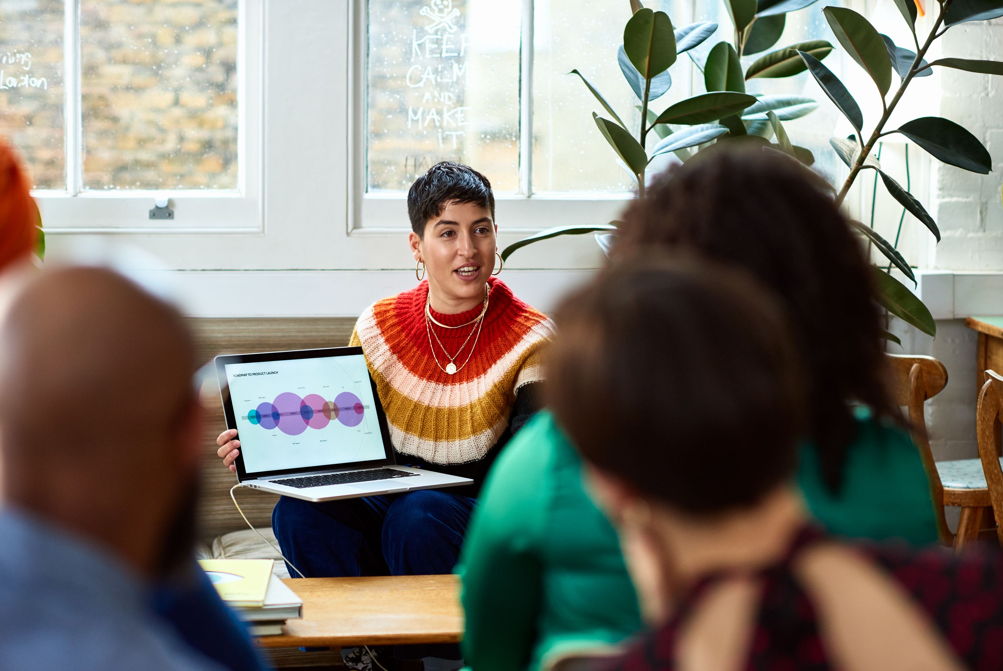 A professional presents their laptop screen to a small group of people.