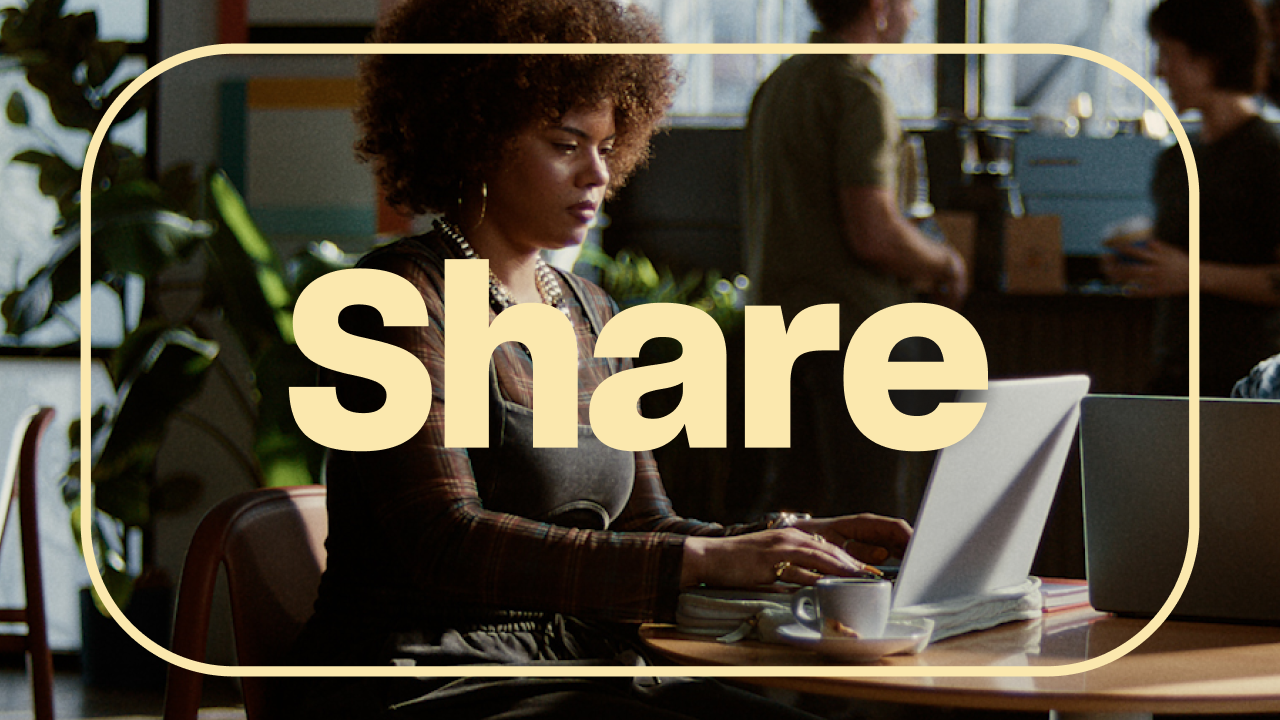 Person working on a laptop at a café table, with the word “Share” in large text over the image and a rounded border framing the scene.