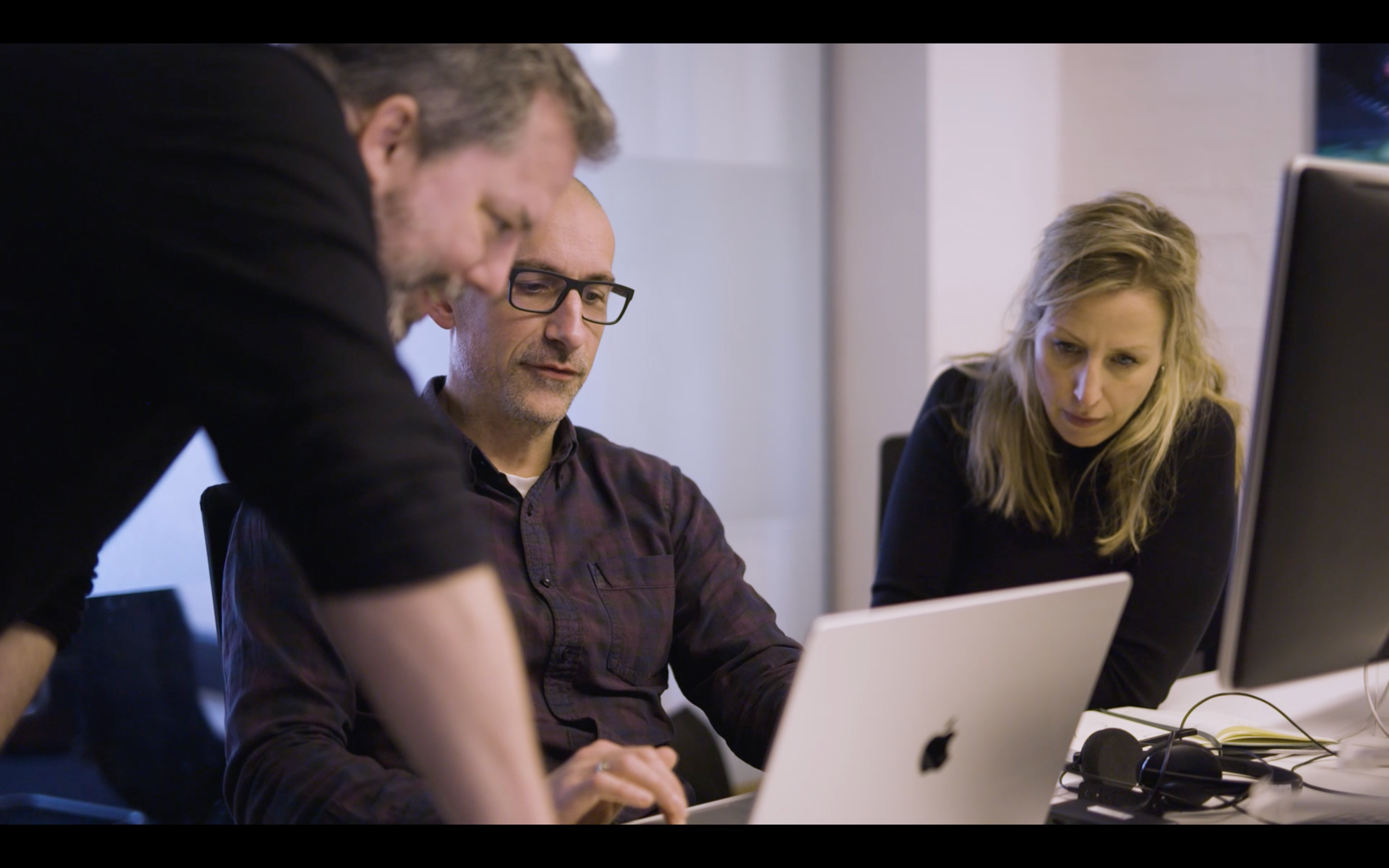 Tre personer, der ser noget på en computer.