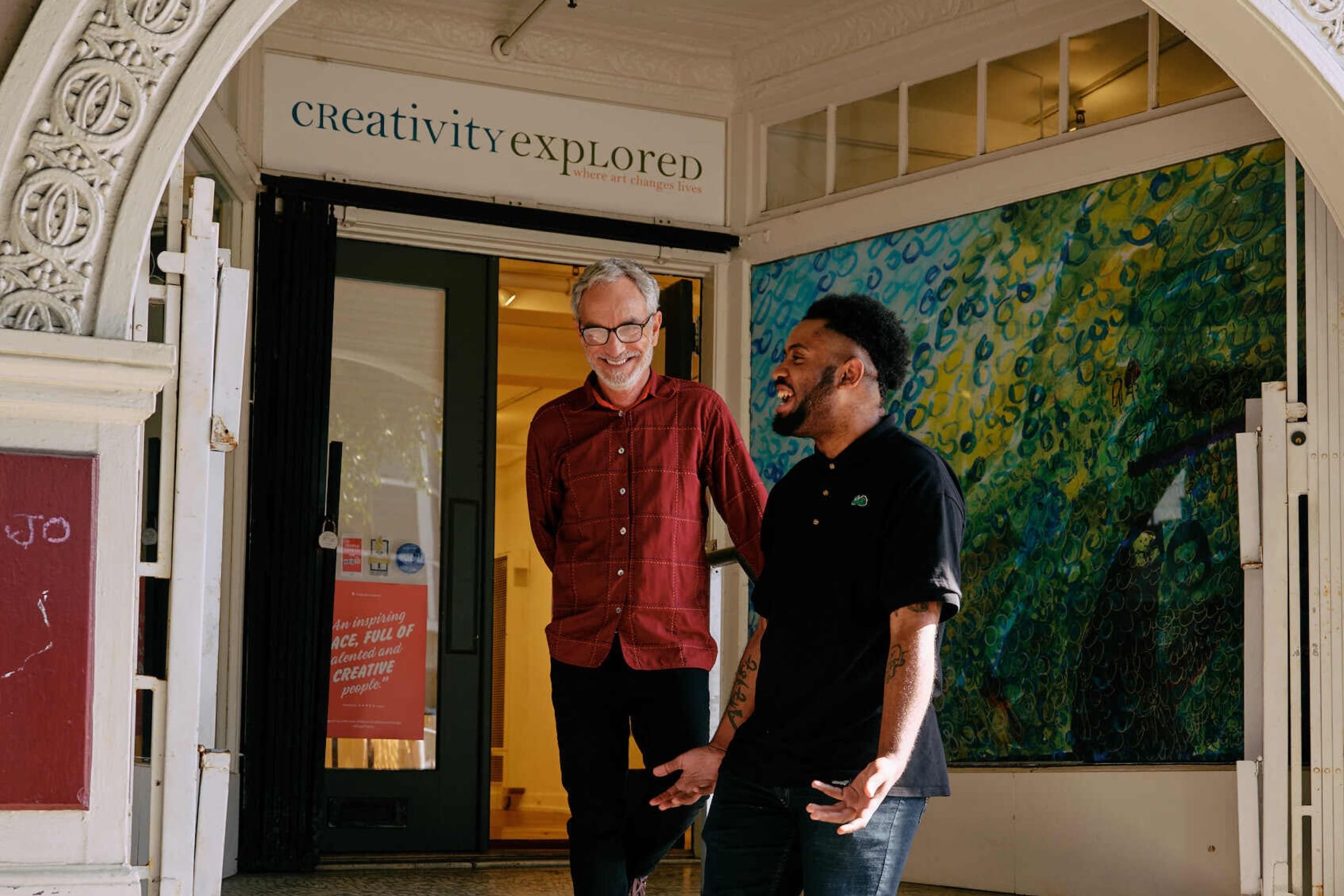 Deux personnes se tenant debout sur des marches devant les locaux de Creativity Explored