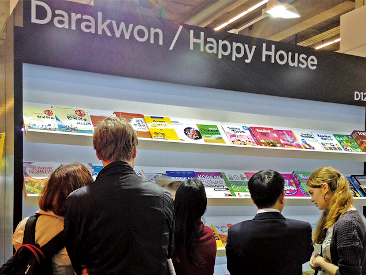 Five people standing at a large display shelf showcasing books