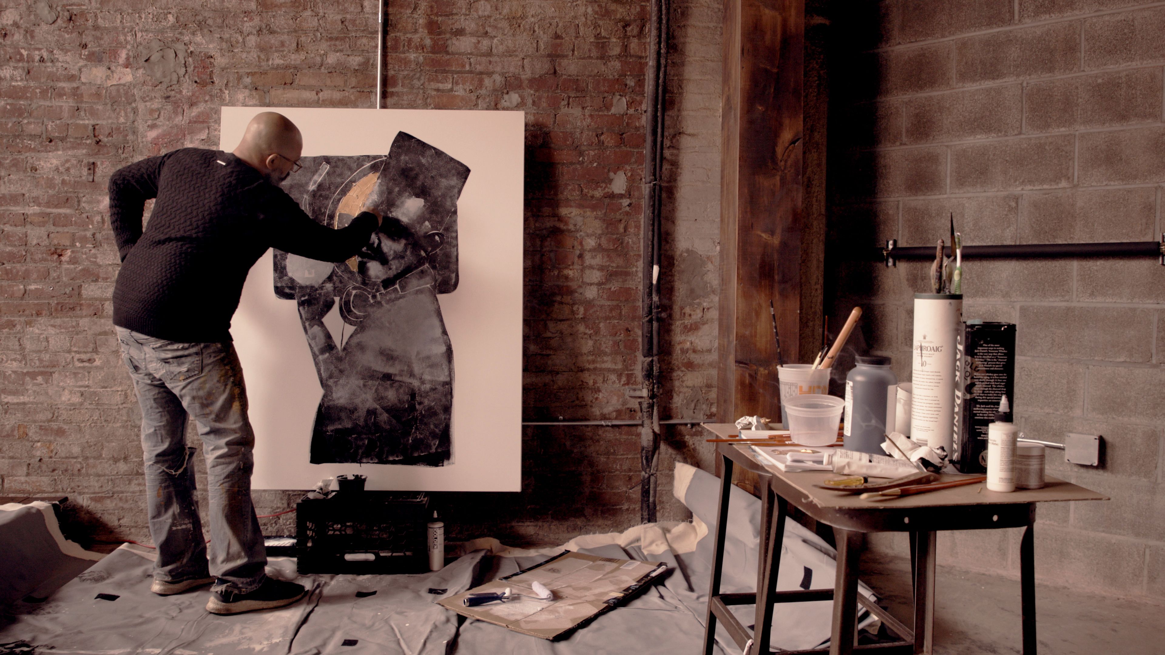 David Cooper em pé diante de uma tela, pintando