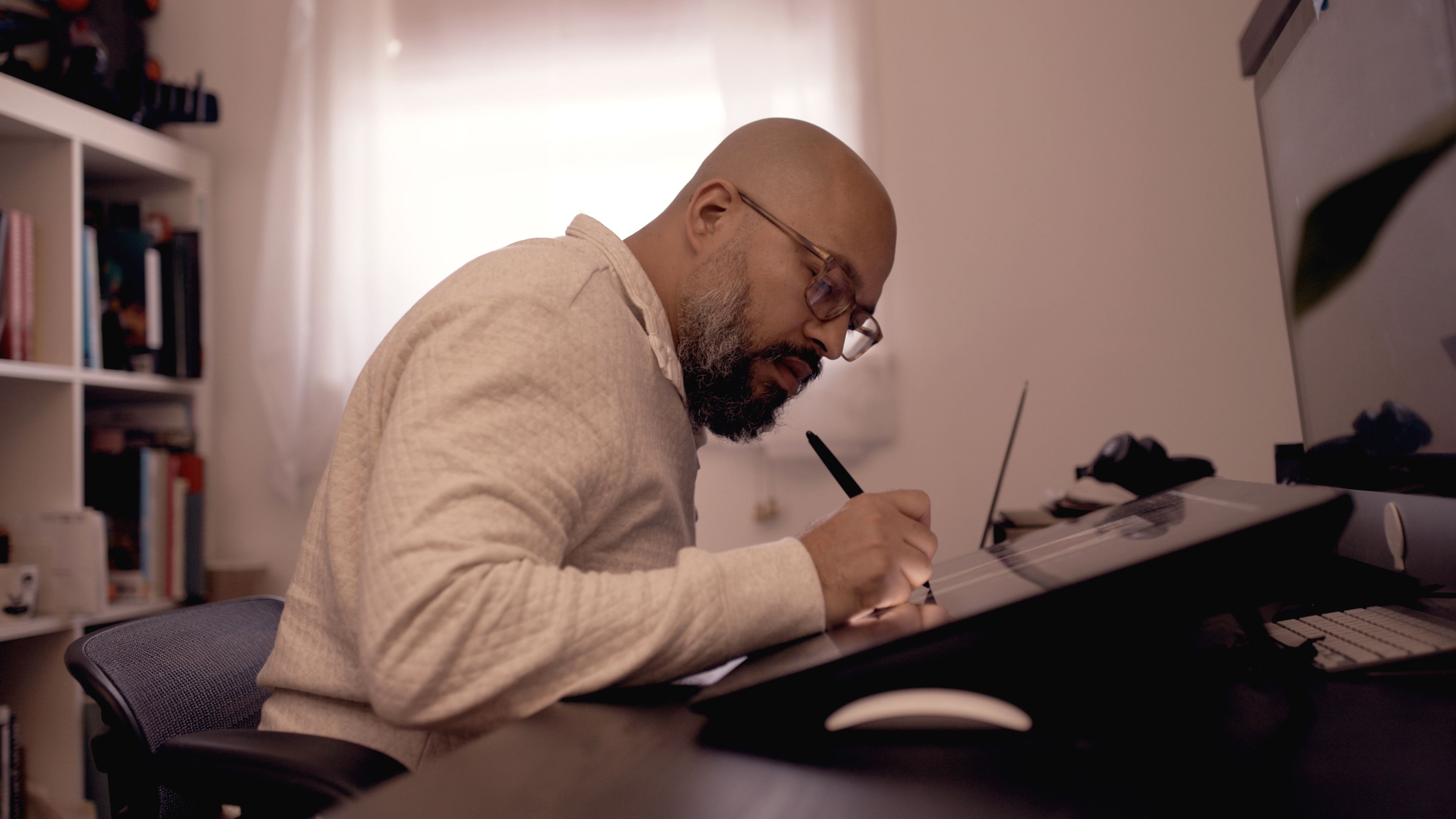 David Cooper alla scrivania mentre lavora utilizzando un pennino su uno schermo