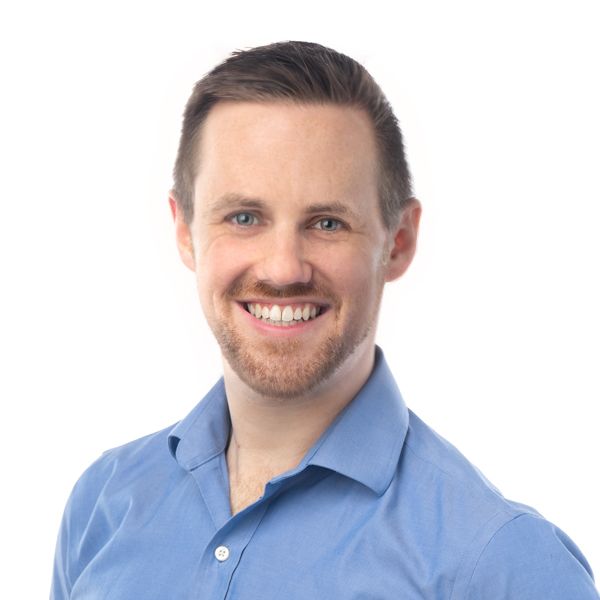 Zach Yokum headshot, in a blue shirt in front of a white background.