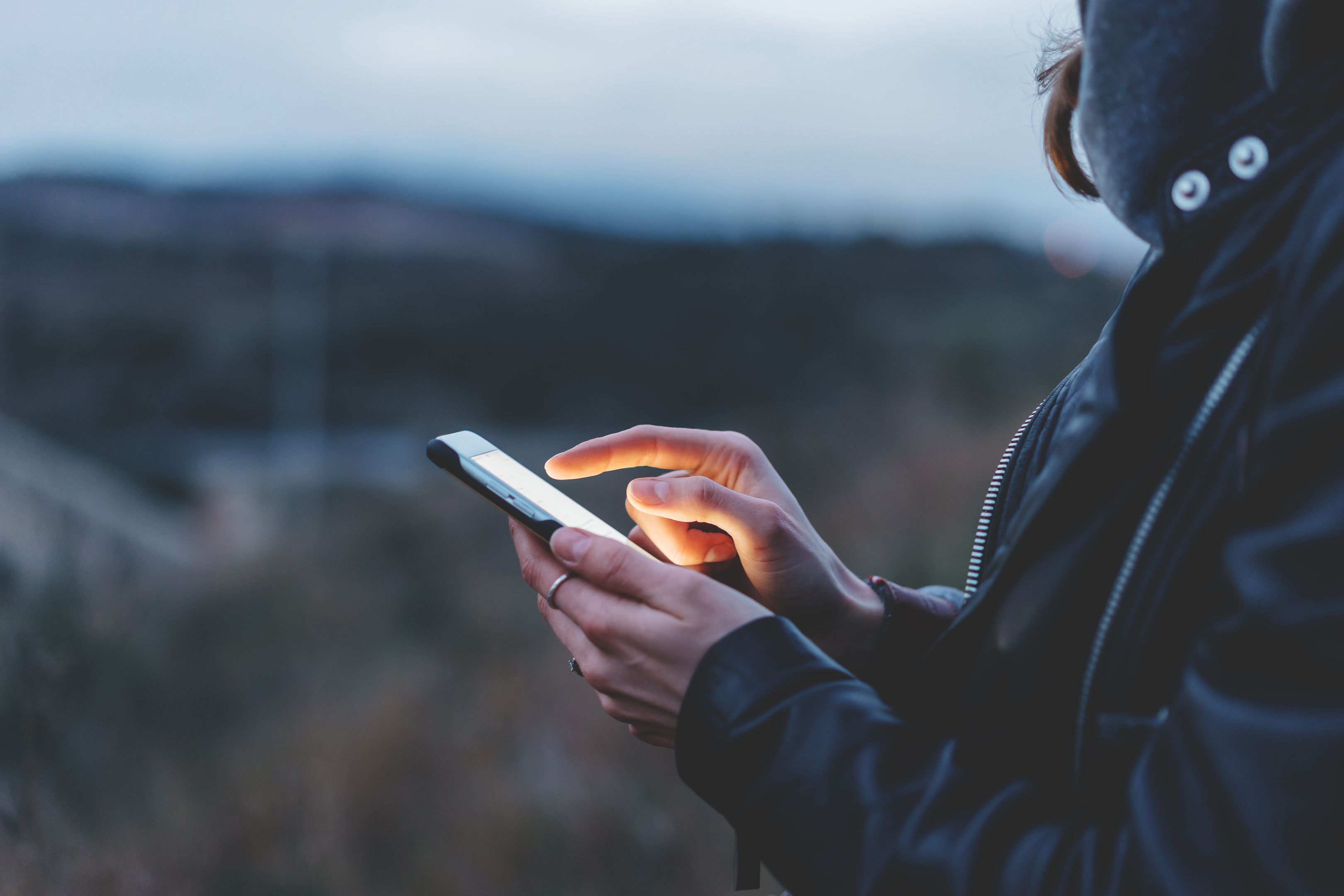 Seorang mengetik pada telefon semasa di luar