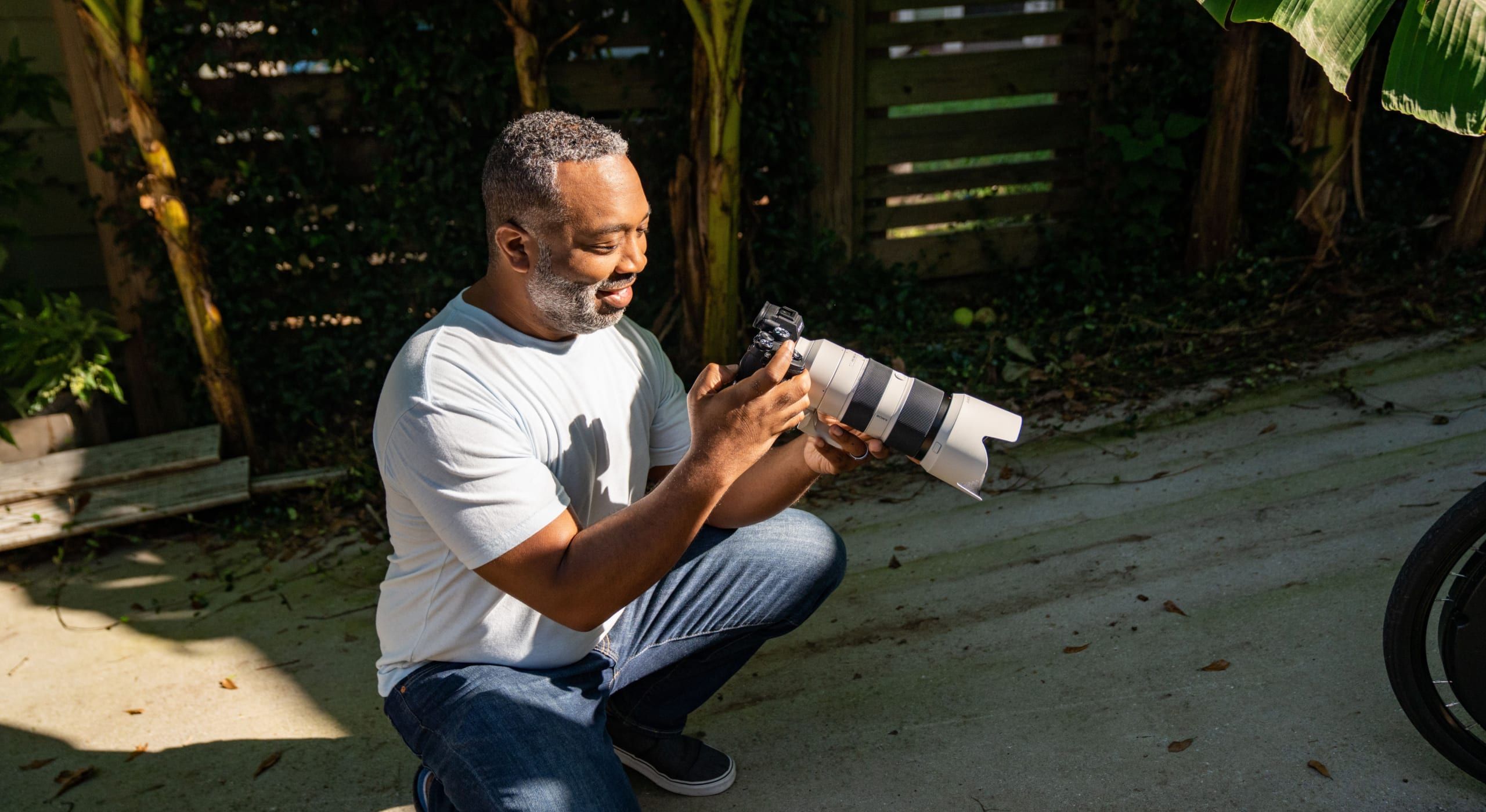 A man looking at the photos he has taken with his digital camera