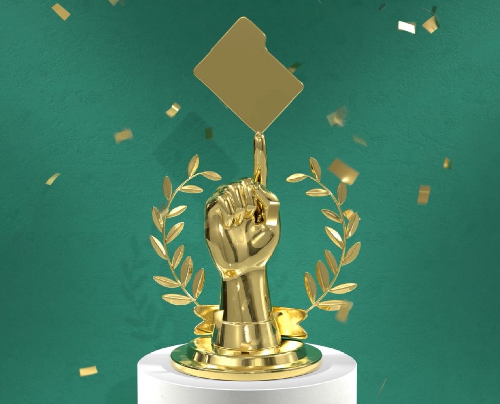 Piala emas tangan yang dikepal dengan jari tengah dilunjurkan untuk menyeimbangkan folder