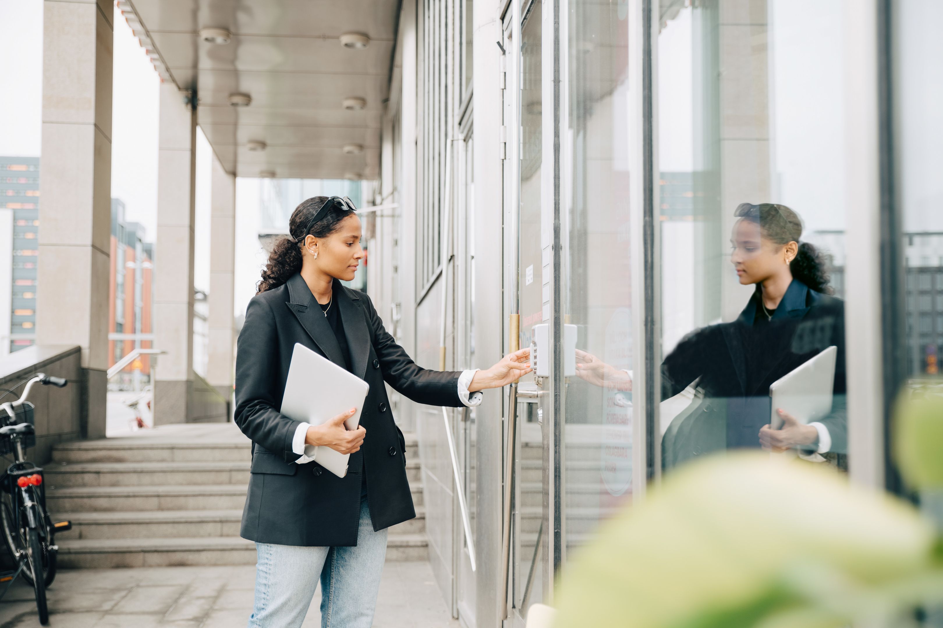A person uses a keypad to enter an office building. 