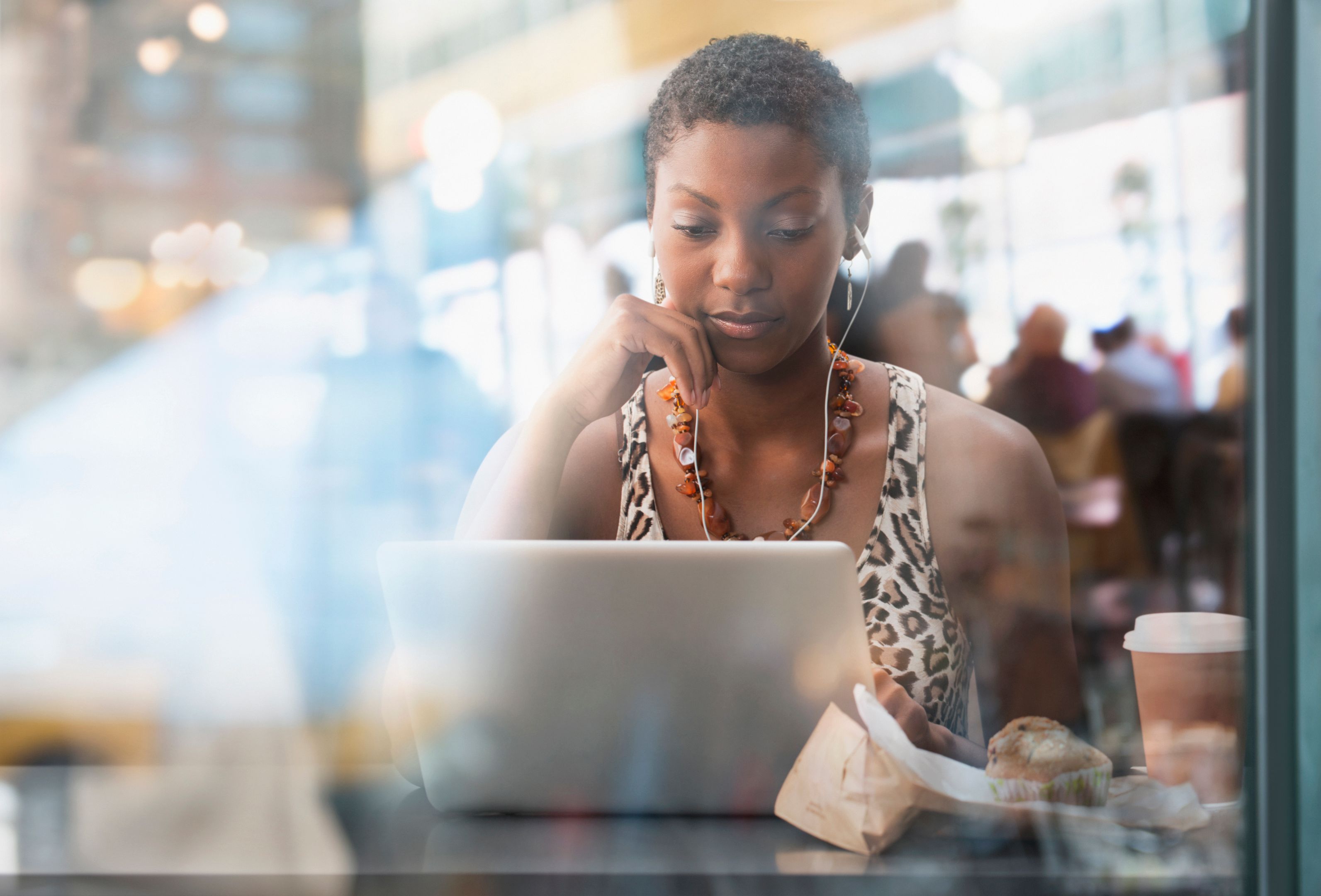 A person works on a laptop in a cafe.