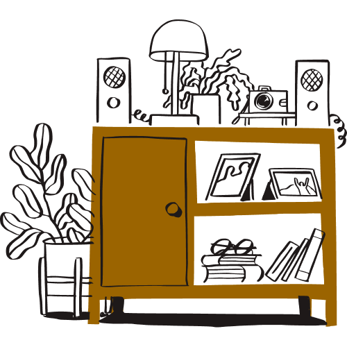A filing cabinet and shelving unit with books, framed pictures, a lamp, speakers, and plants.