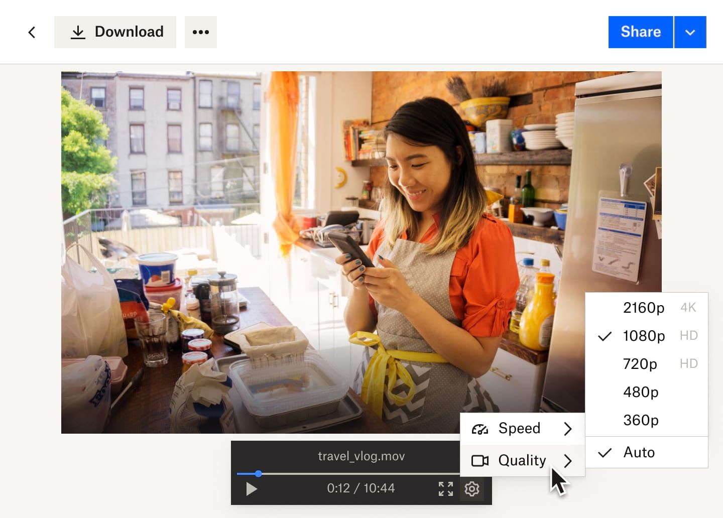 A drop down from the settings button shows video speed and video quality options for the Dropbox video file of a woman working in a bakery.