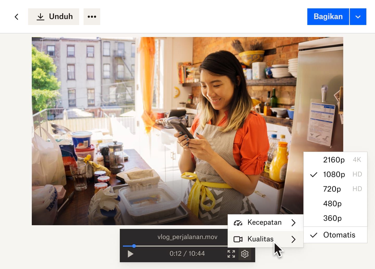 Menu drop-down dari tombol pengaturan menampilkan opsi kecepatan video dan kualitas video untuk file video Dropbox seorang wanita yang bekerja di toko roti.