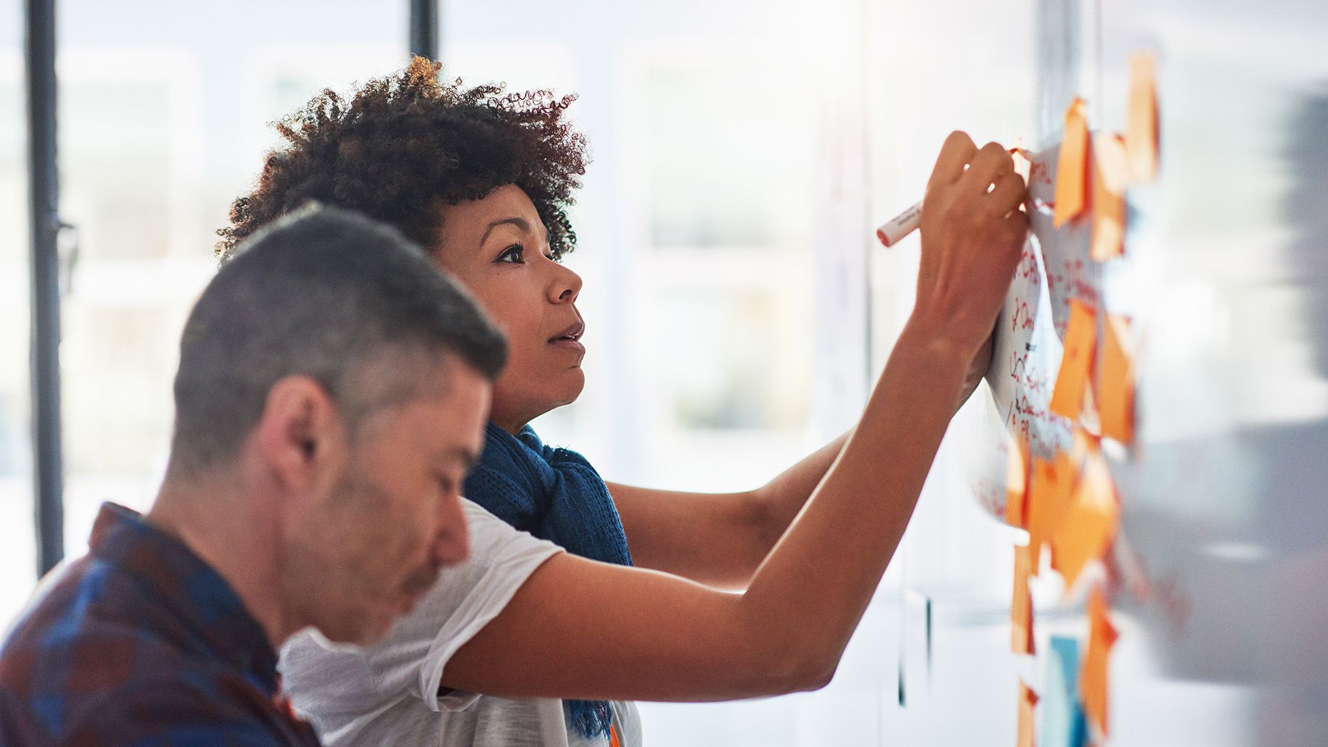 Two people map out their file management strategy on a whiteboard.