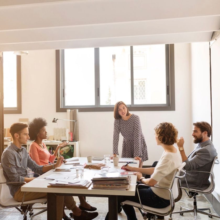 Five team members work together at a table in an office.