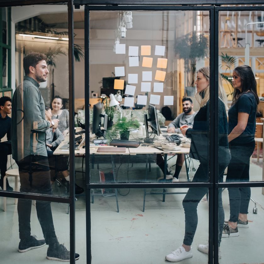 A team using Dropbox and Asana to streamline their workflows participate in a stand-up meeting.