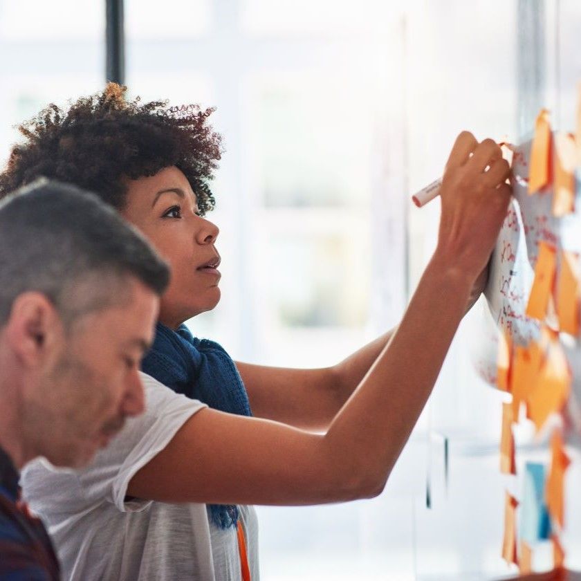 Two people map out their file management strategy on a whiteboard.
