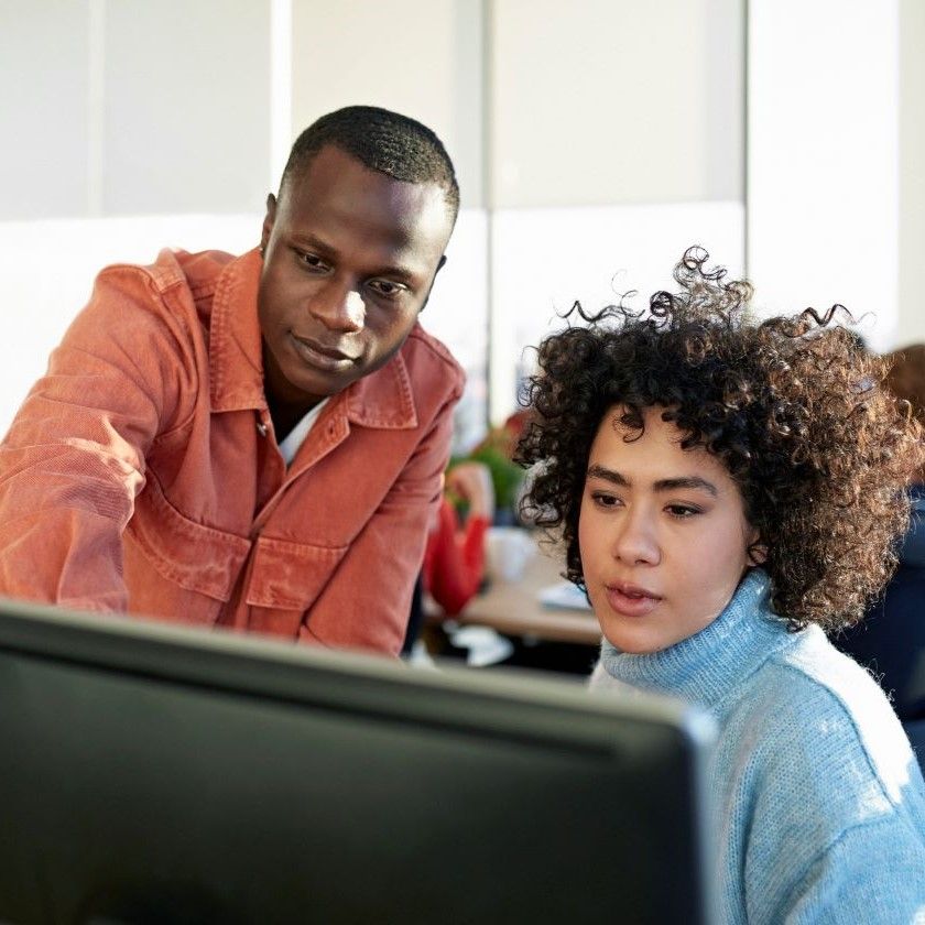 Two people compare Android cloud storage with Dropbox services in an office.