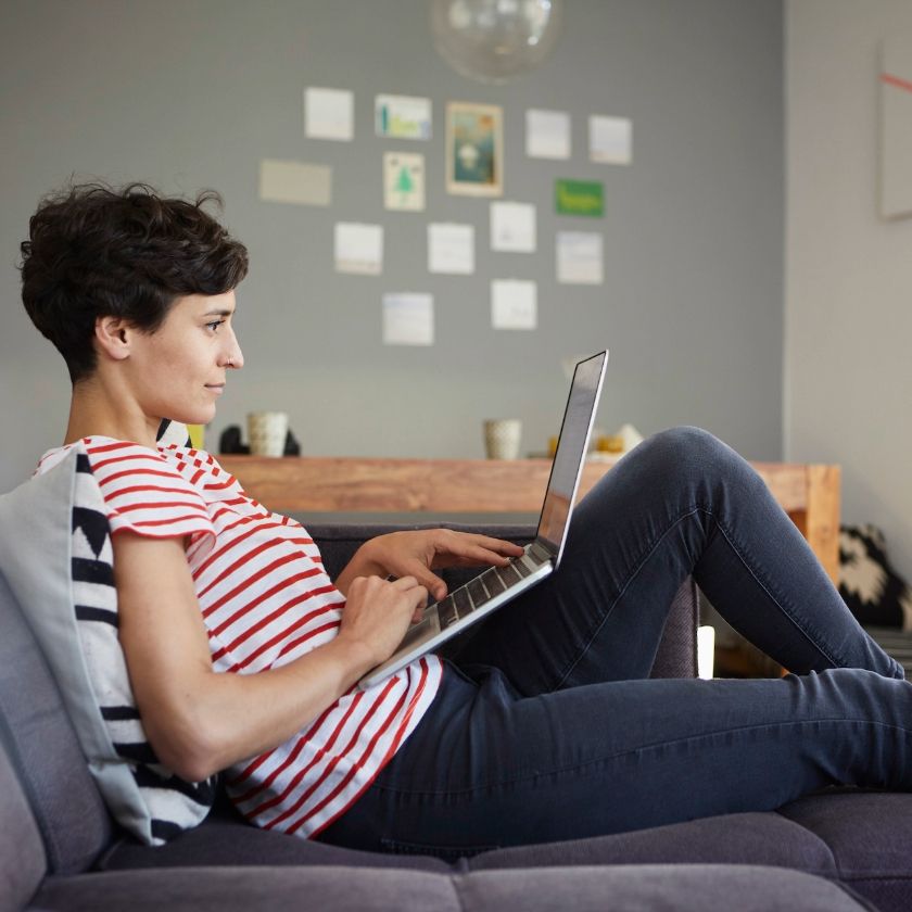 A freelance artist works on their laptop at home.