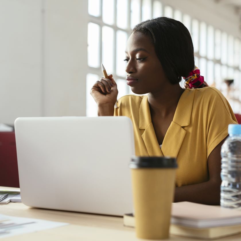 A person sits at their home desk while reading about cloud storage for modern teams on a laptop.