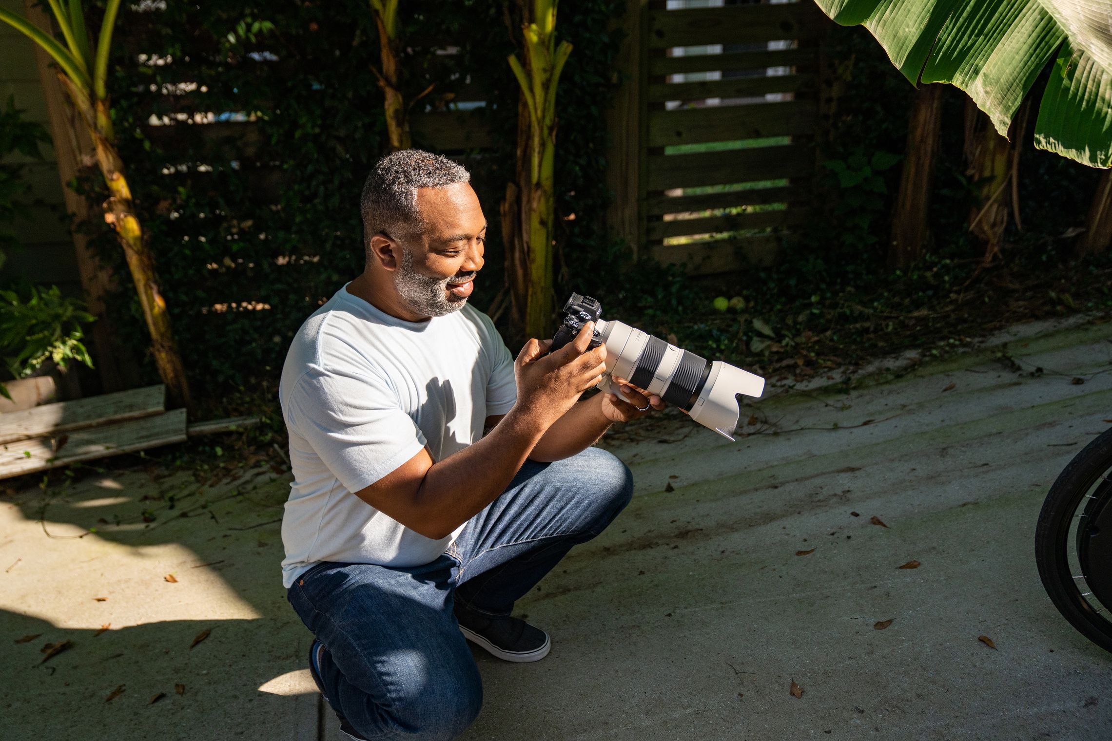 A photographer reviews photos on a DSLR camera before uploading them to cloud storage.