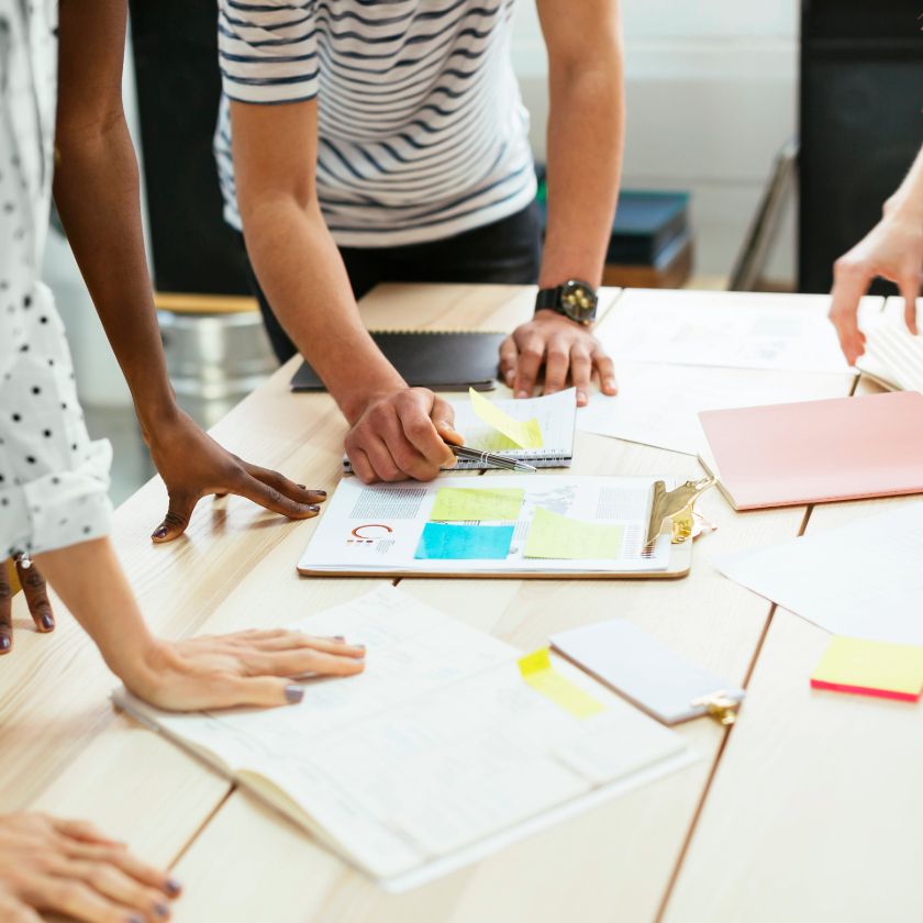 A group of people hash out collaboration challenges while discussing the situation over a meeting table.
