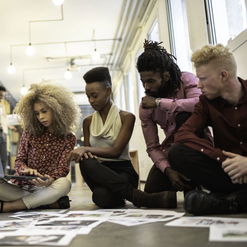 A group of colleagues map out their content supply chain with pieces of paper in their office space.