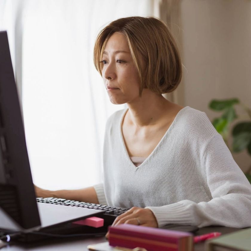 A person working at a desk on a computer, possibly converting file formats like DJVU to PDF in a home office.