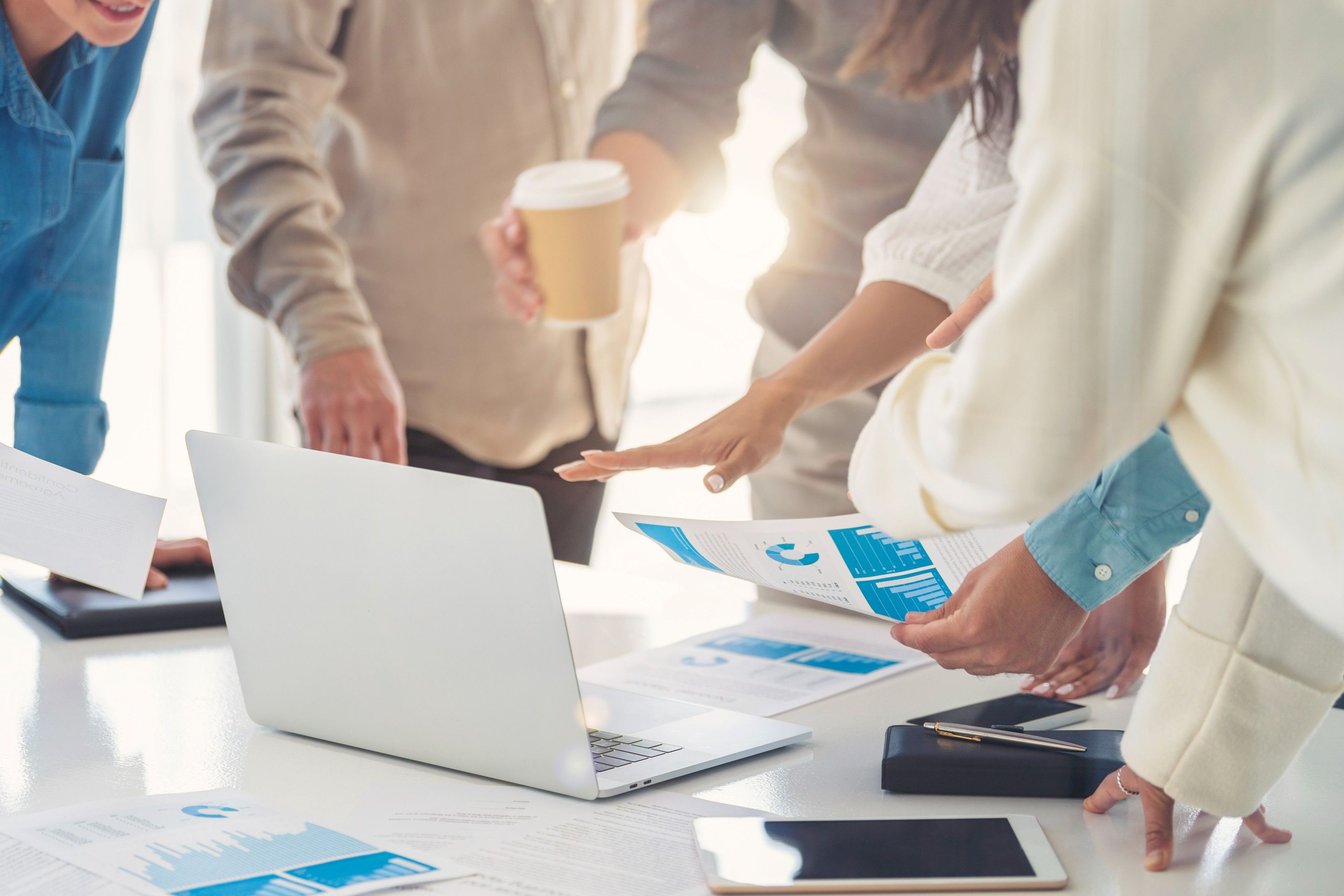 A group of people gather around a table while discussing document analytics.