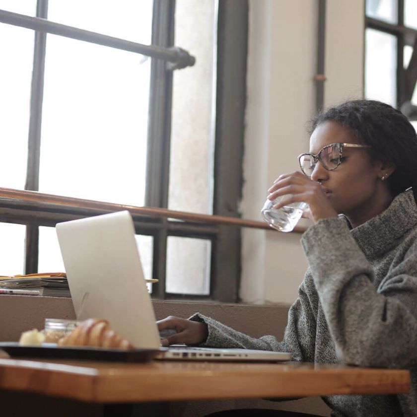 A person in an office environment manages their inbox using their laptop.