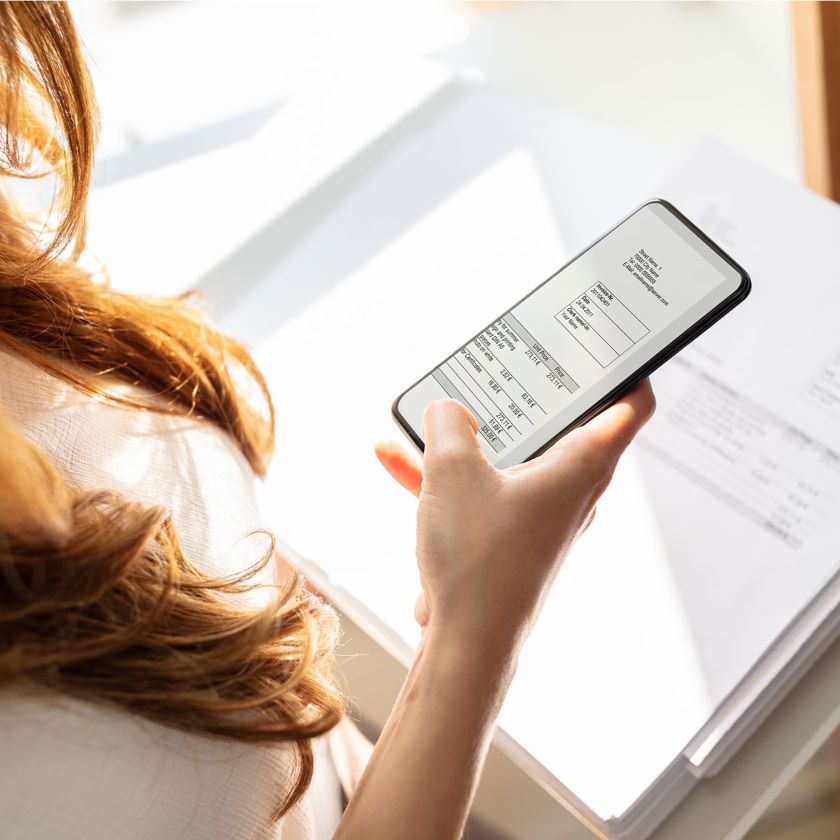 A person scans documents with their phone to create secure digital backups.