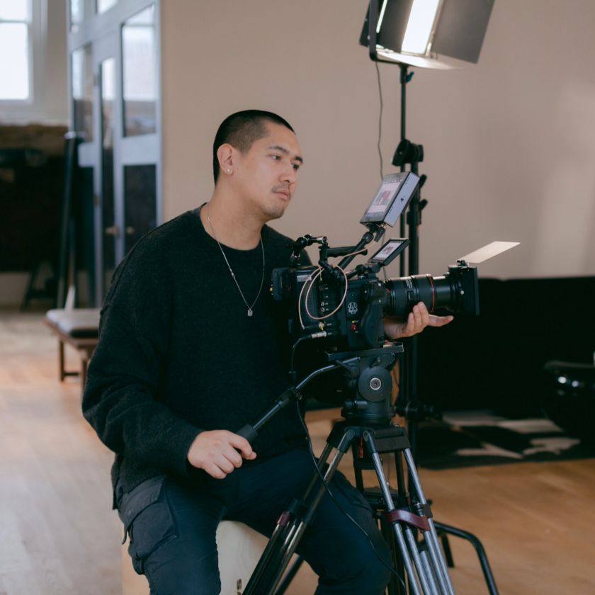 Video creator operating a professional camera setup in a studio, focused on capturing high-quality footage.