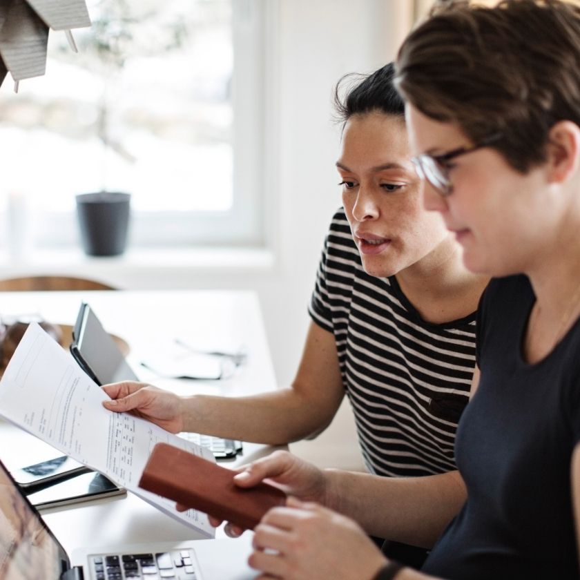 Two freelance professionals look over an invoice together.
