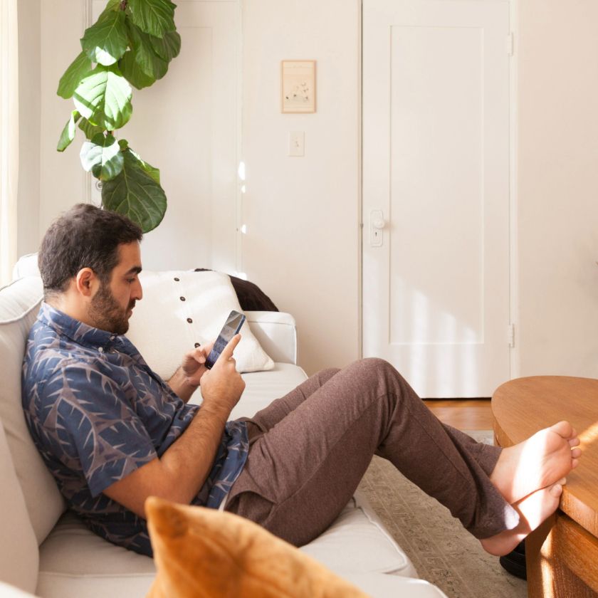 A remote worker uses their phone to communicate with colleagues out of work hours.